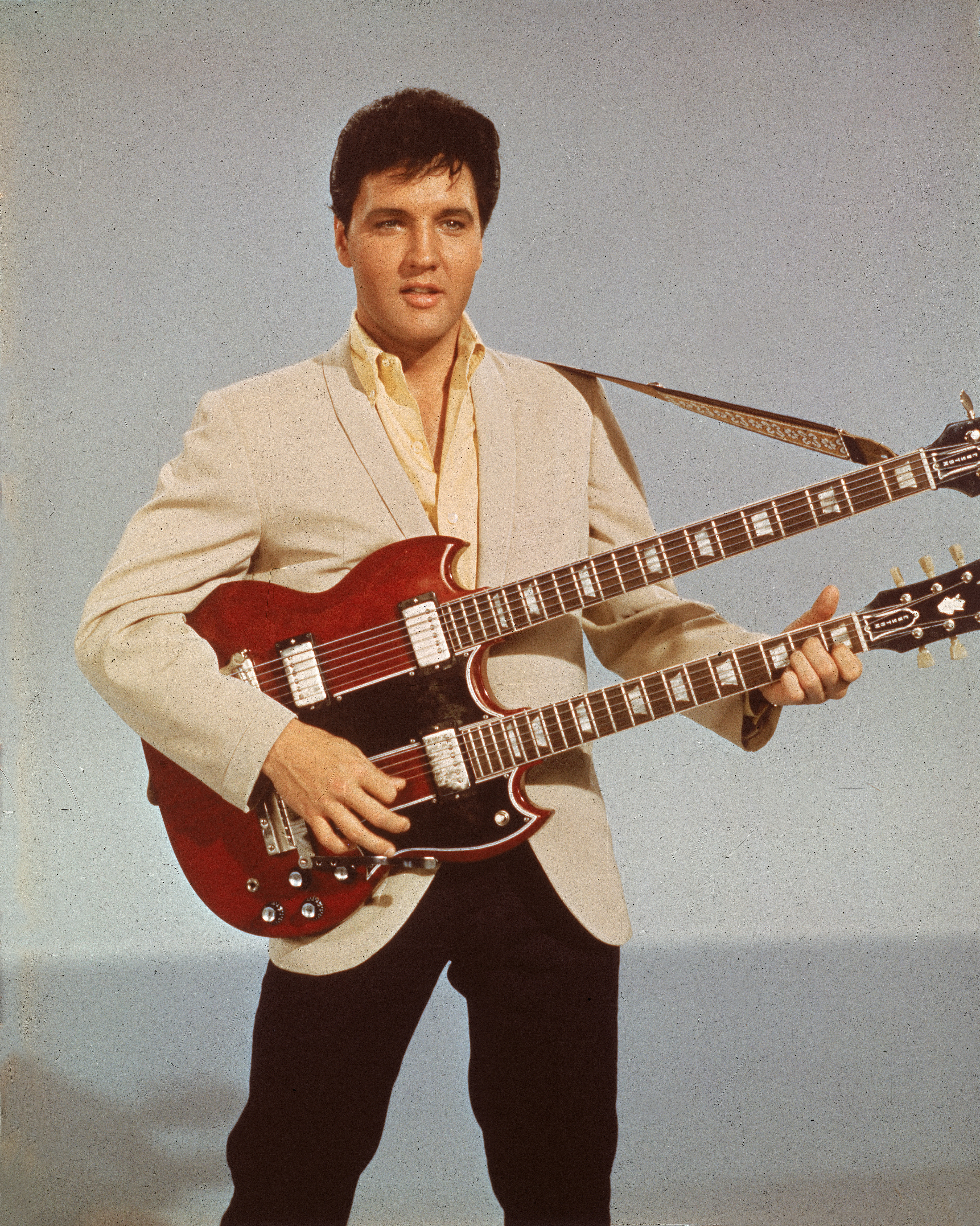 Portrait of American singer and actor Elvis Presley (1935 - 1977) holding a 1965 Gibson EBS-1250 Double Bass (a combined 6-string and bass guitar), circa 1966. Elvis is seen playing the guitar in his 1966 film,