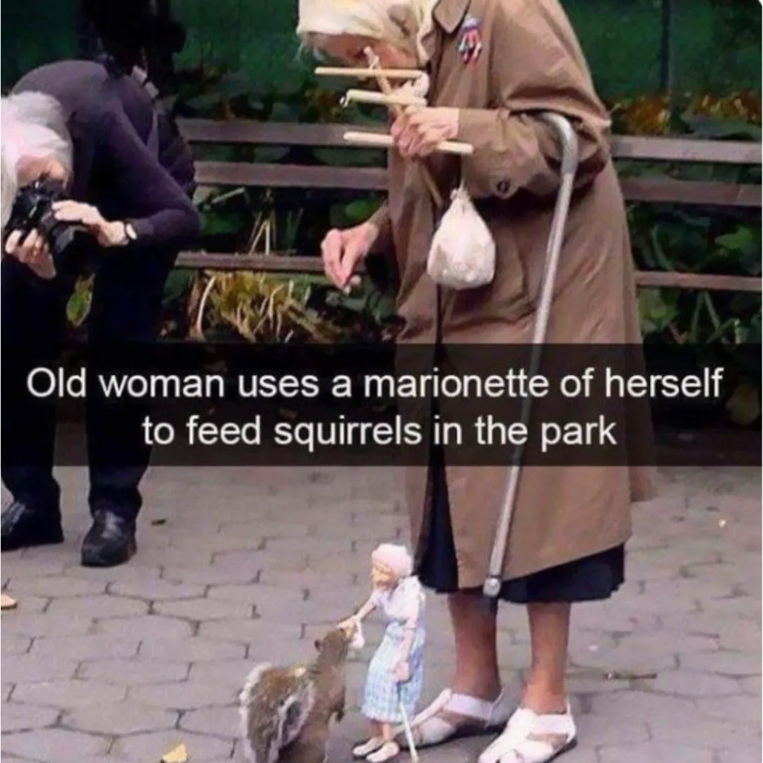 a woman using a marionette puppet to feed squirrels at the park