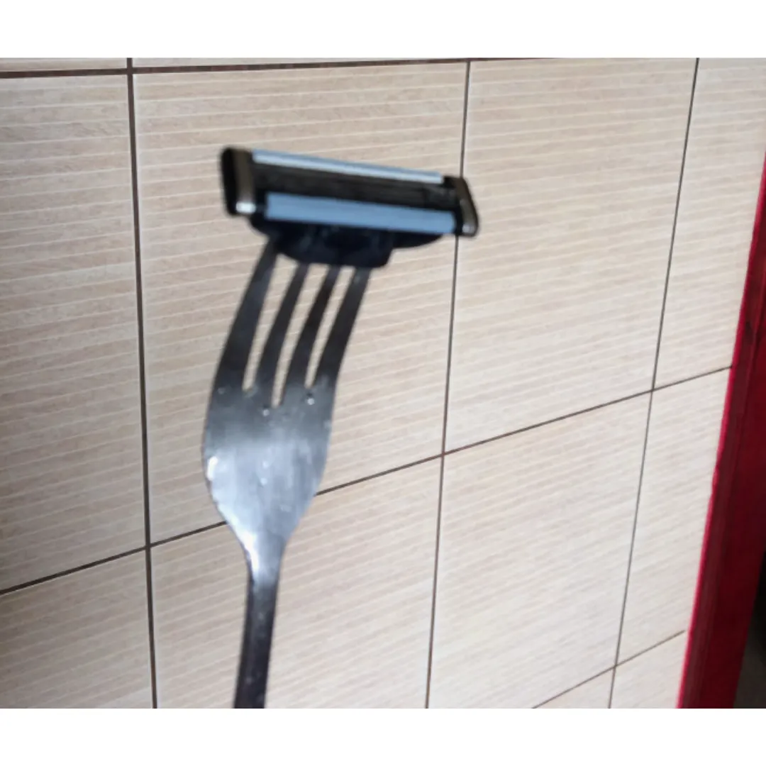 fork with a shaving razor attached to the prongs