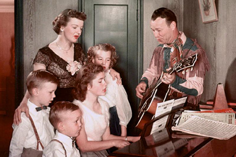 Roy Singing Around The Piano with children and family