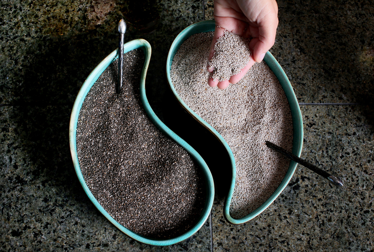 Chia seeds have healthy fatty acids that prevent heart disease Black and White Chia seeds sit in ying-yang shaped dishes