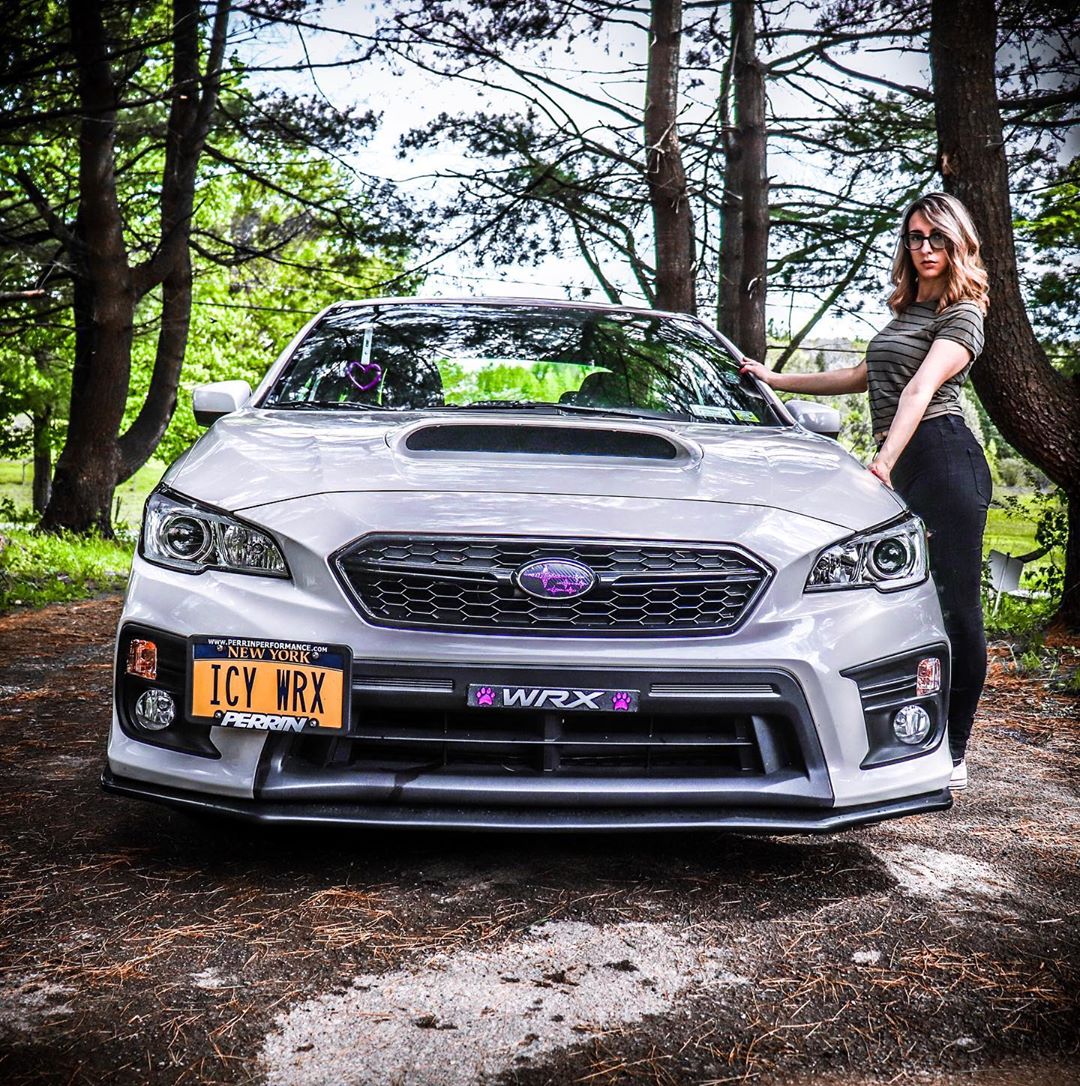 subaru subaru and young lady standing there next to it