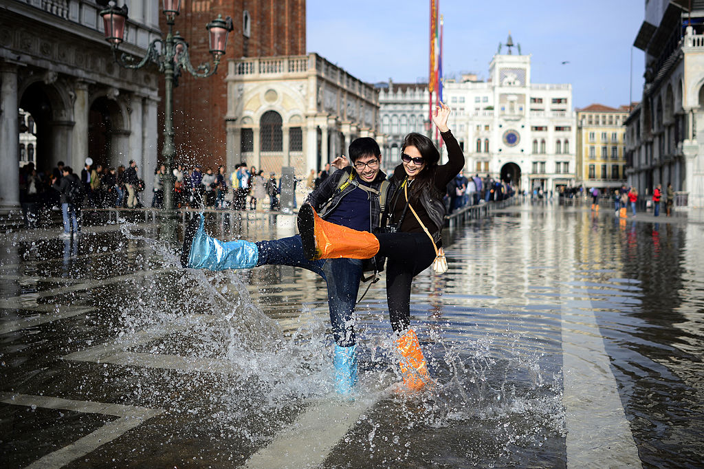 A just married Canadian couple on a honey moon trip in Venice plays with the water in front of the Doge's Palace-186794976 A just married Canadian couple on a honey moon trip in Venice plays with the water in front of the Doge's Palace-186794976