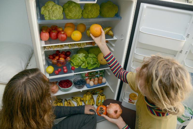 soda two girls picking out veg from fridge