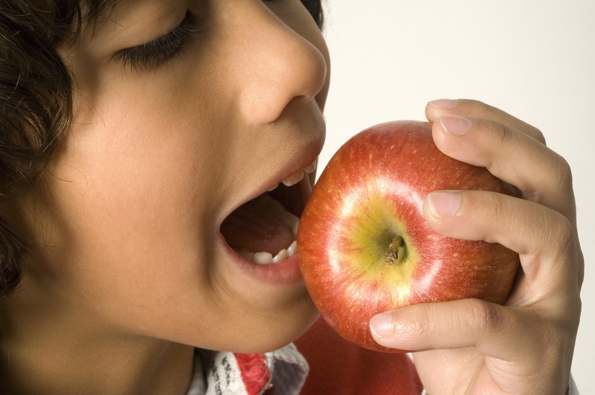 eating apples clean teeth-129378608 Close-up of boy eating apple.