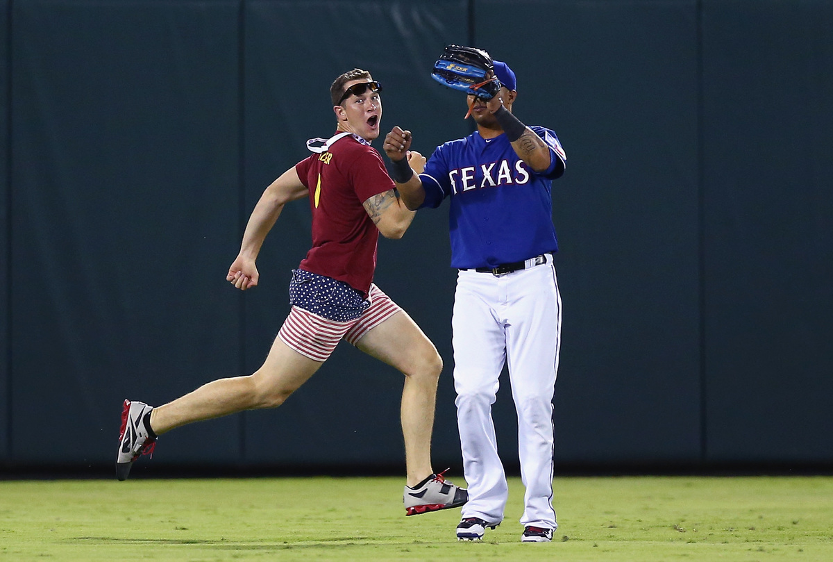 fan on the field-480444986 A fan runs across the field past Leonys Martin #2 of the Texas Rangers in the top of the eighth inning at Globe Life Park in Arlington on July 11, 2015 in Arlington, Texas.