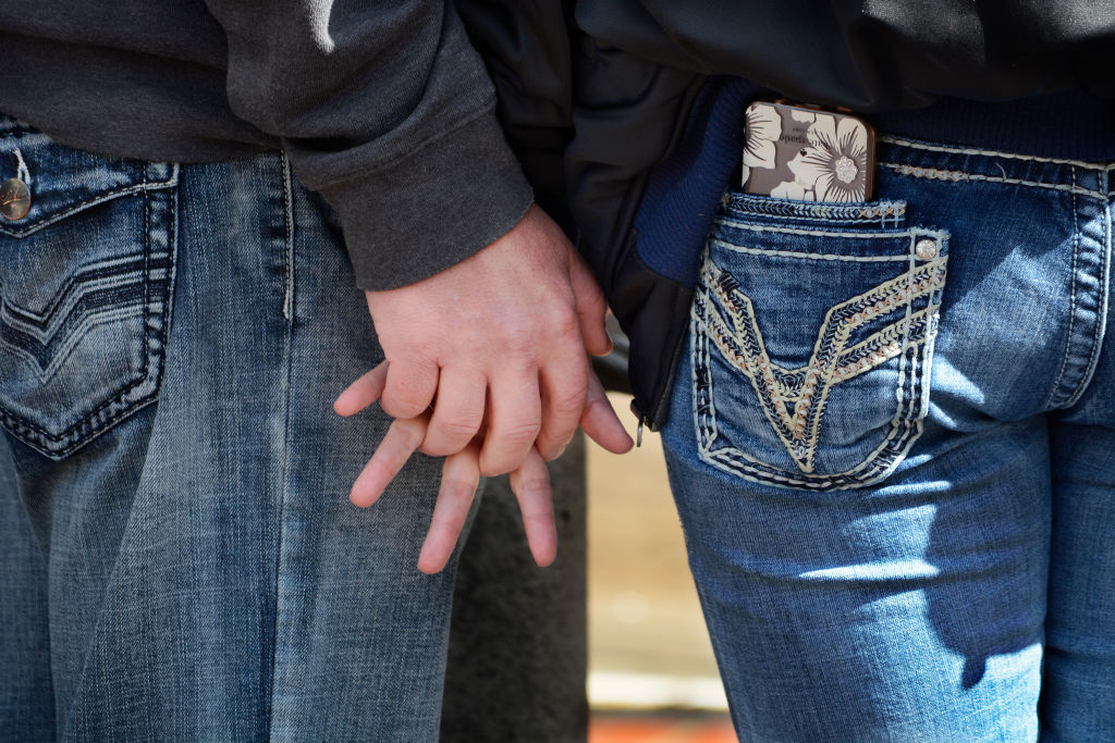 A couple hold hands in San Francisco, California.