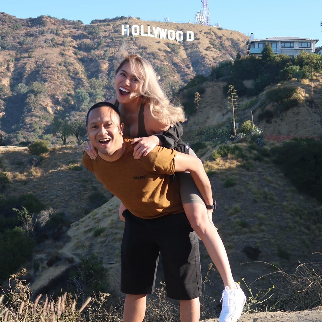 near the hollywood sign stands a couple 