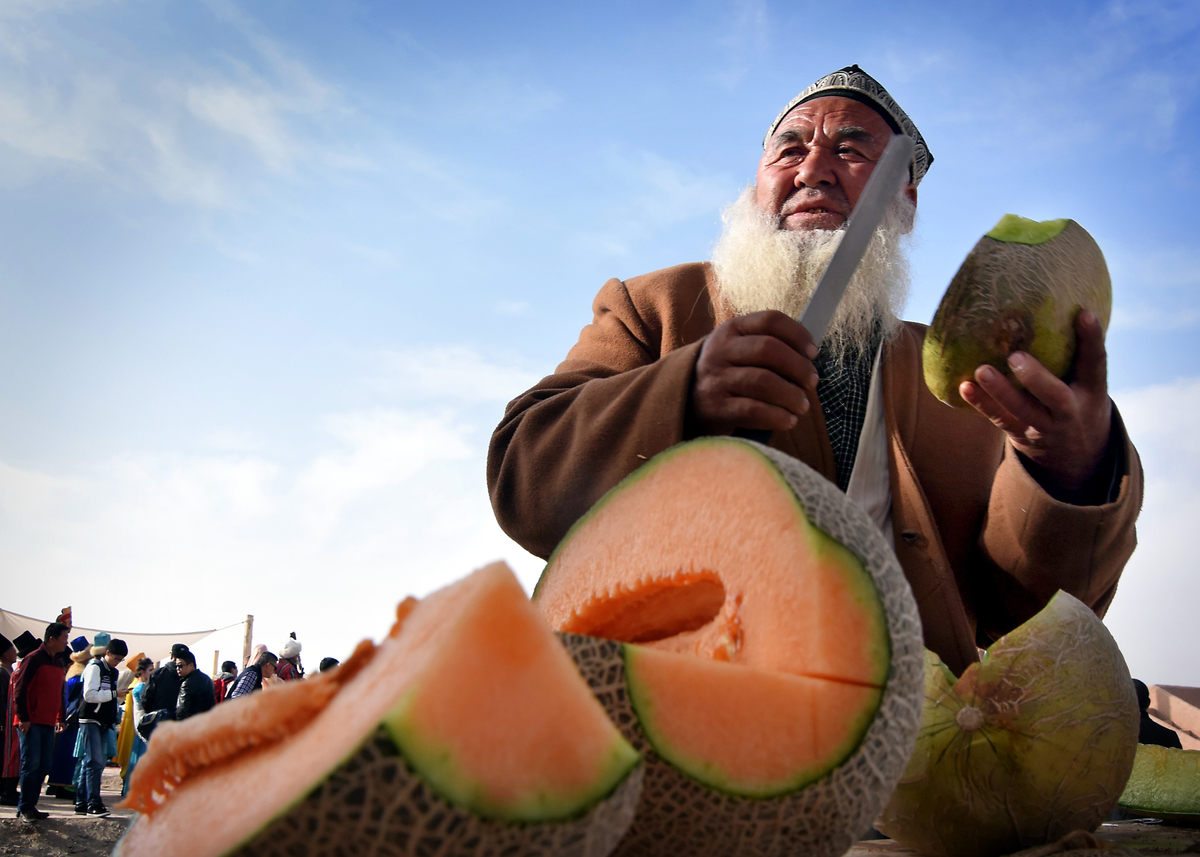 cutting cantaloupe - 495396952 A vender sells Hami melons, a popular cantaloupe