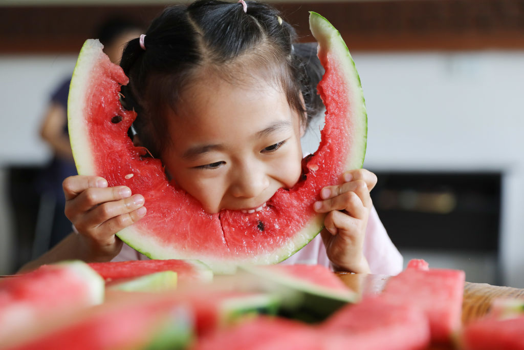 melon 1166563737 a young girl eating a big piece of watermelon