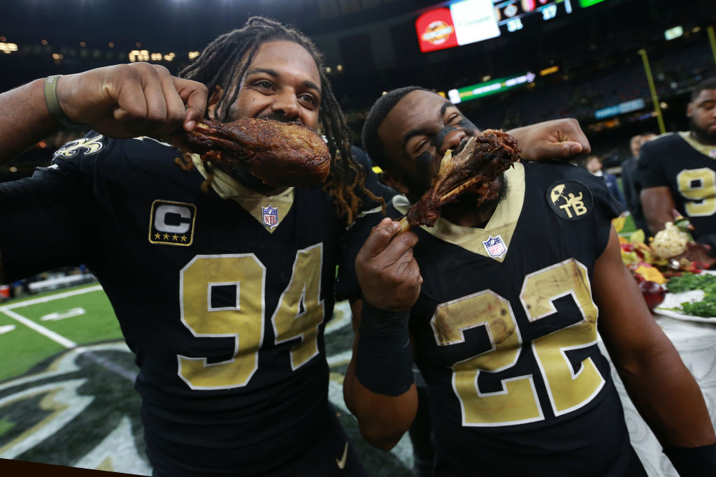 turkey 1064360044 cameron jordan and mark ingram eating turkey legs on a football field