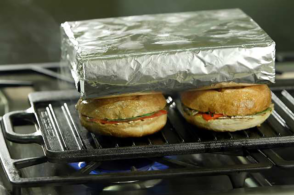Panini Press Brick wrapped in foil on top of sandwiches
