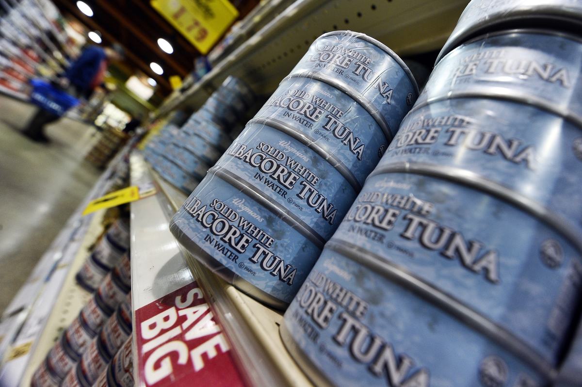 canned tuna - 109408986 Canned tuna lines the shelves of a grocery store.