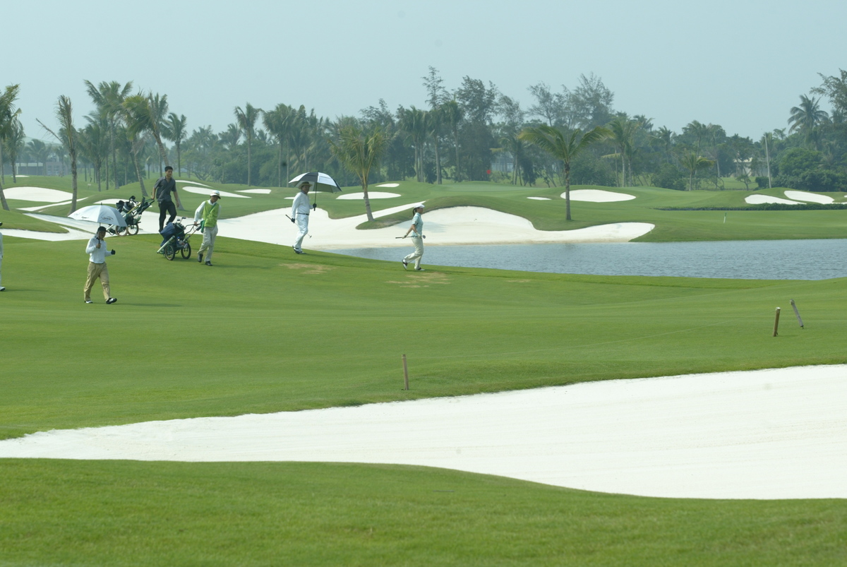 Golfing in China - 1124837820 Golfers walk through a course in Hainan.