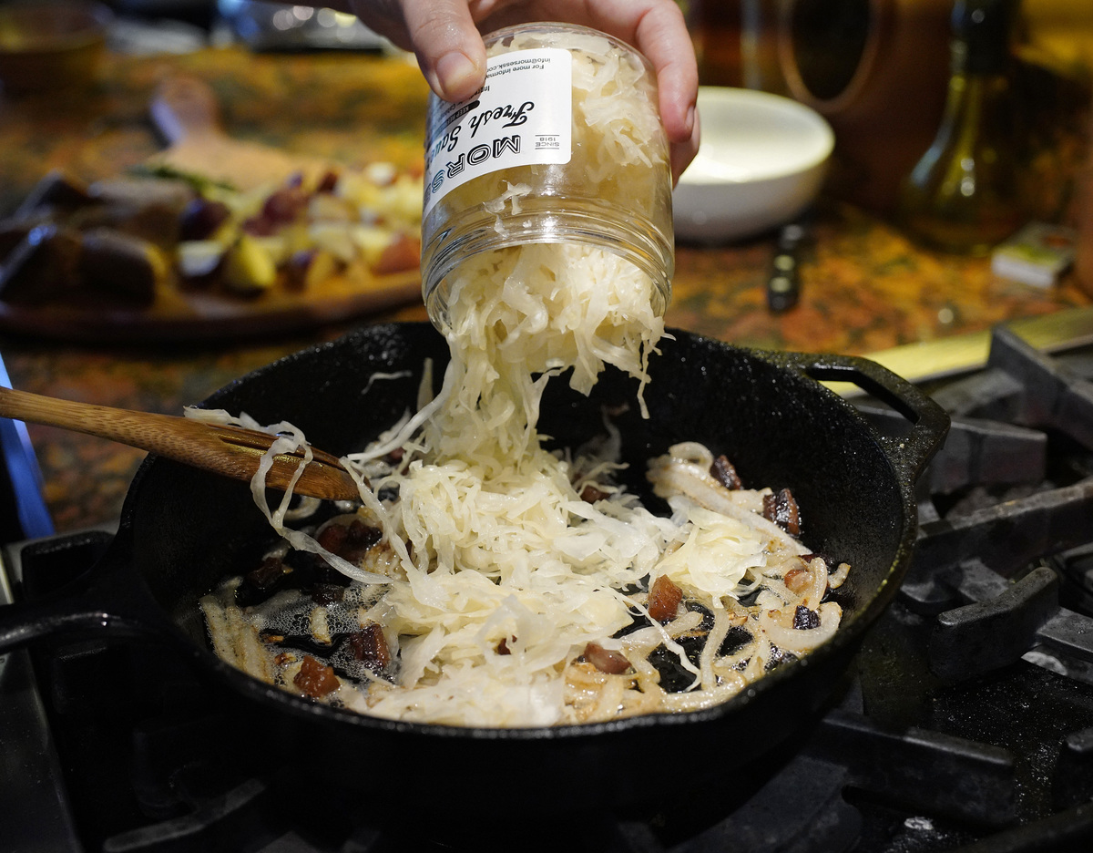 pouring sauerkraut - 1167063170 Cook adds Morses sauerkraut to a pan.