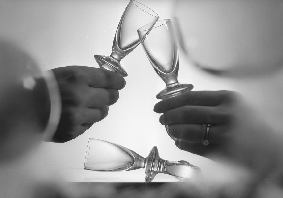 glasses - 1174186234 People cheer with tiny, empty wine glasses in 1970.