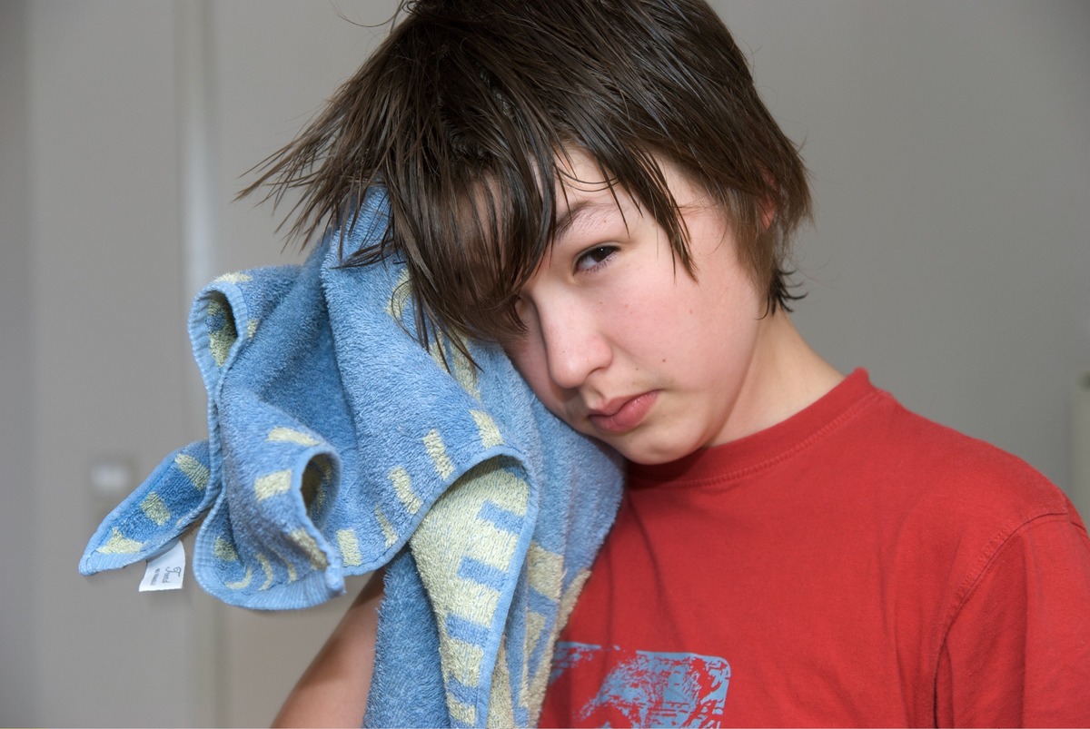 drying hair with a towel - 544996947 A boy dries his hair with a towel.