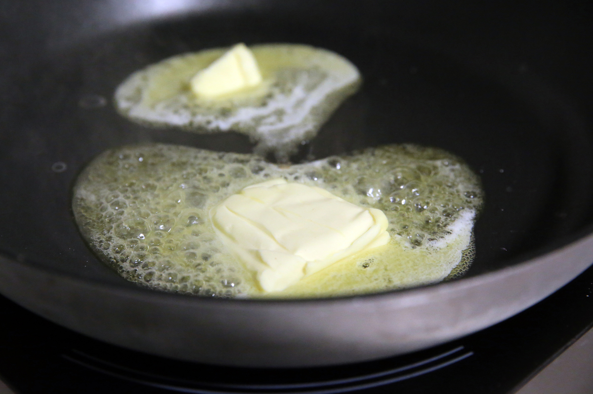 butter in pan - 601099156 Butter fries in a pan, close-up.