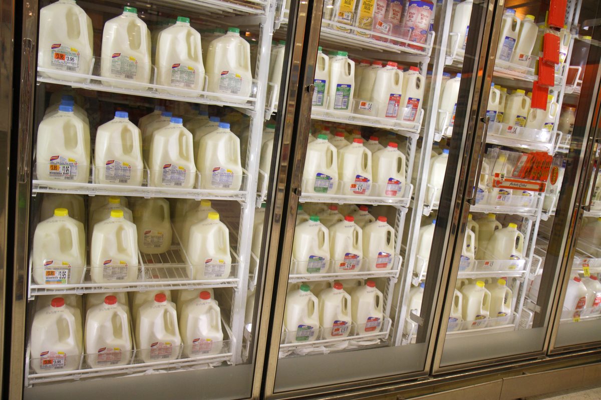 shelves of milk - 635712132 Dairy products are on shelves inside of a refrigerator in Shaw's grocery store.