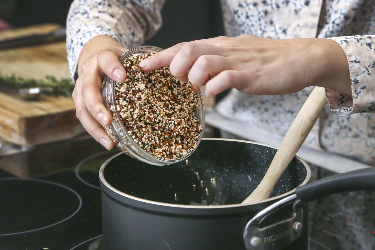 cooking quinoa - 658423430 Cookbook author Laura Wright pours dried quinoa into a pot.