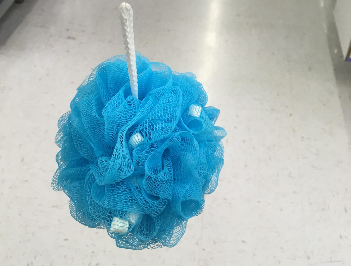blue loofah A blue loofah with soap beads inside of it is inside of a store.