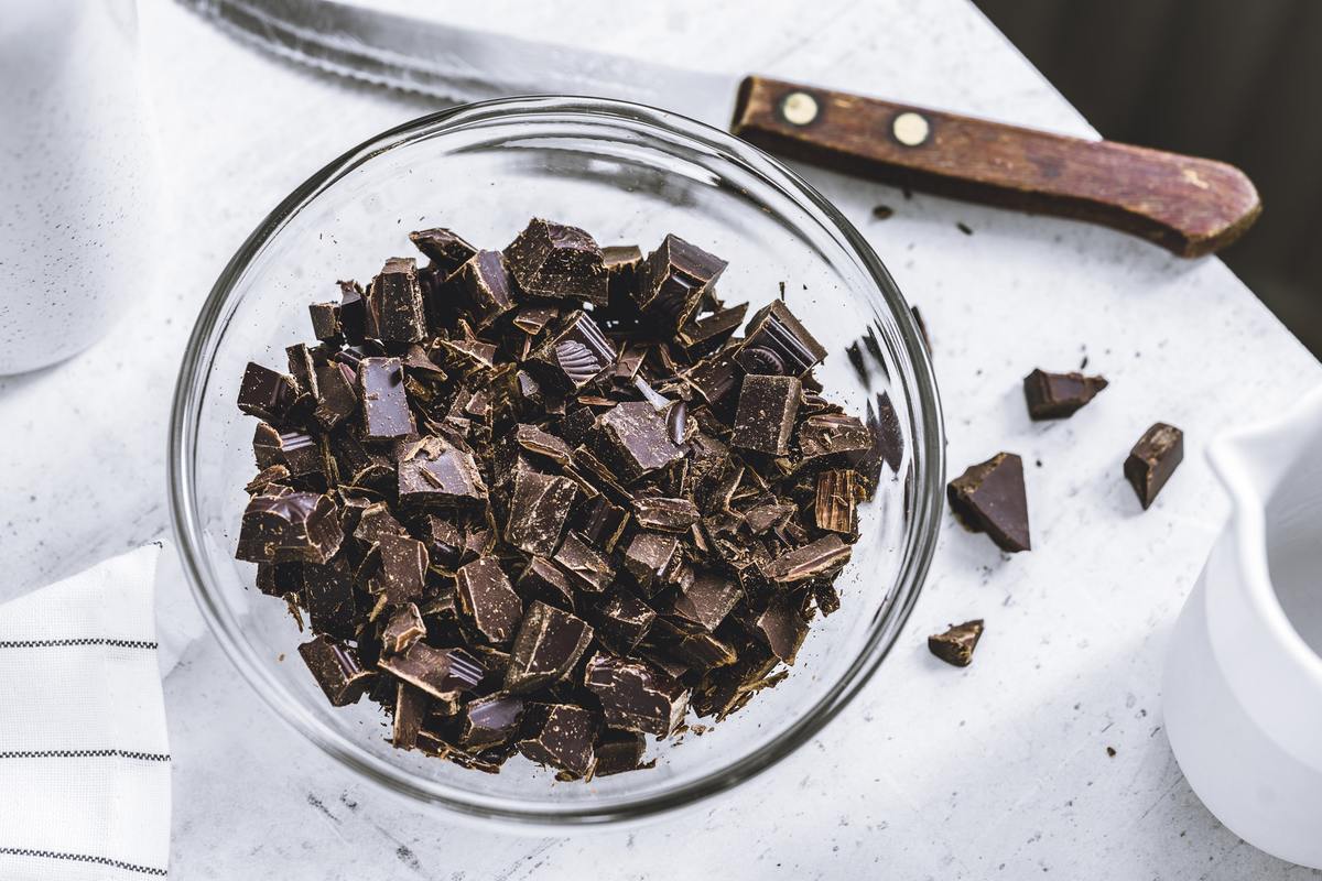 chopped dark chocolate Chopped dark chocolate is gathered in a glass bowl.