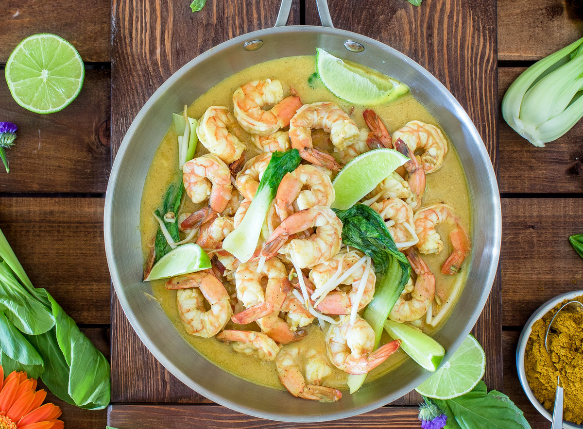curry shrimp A pan of curry shrimp lies against a wooden table.