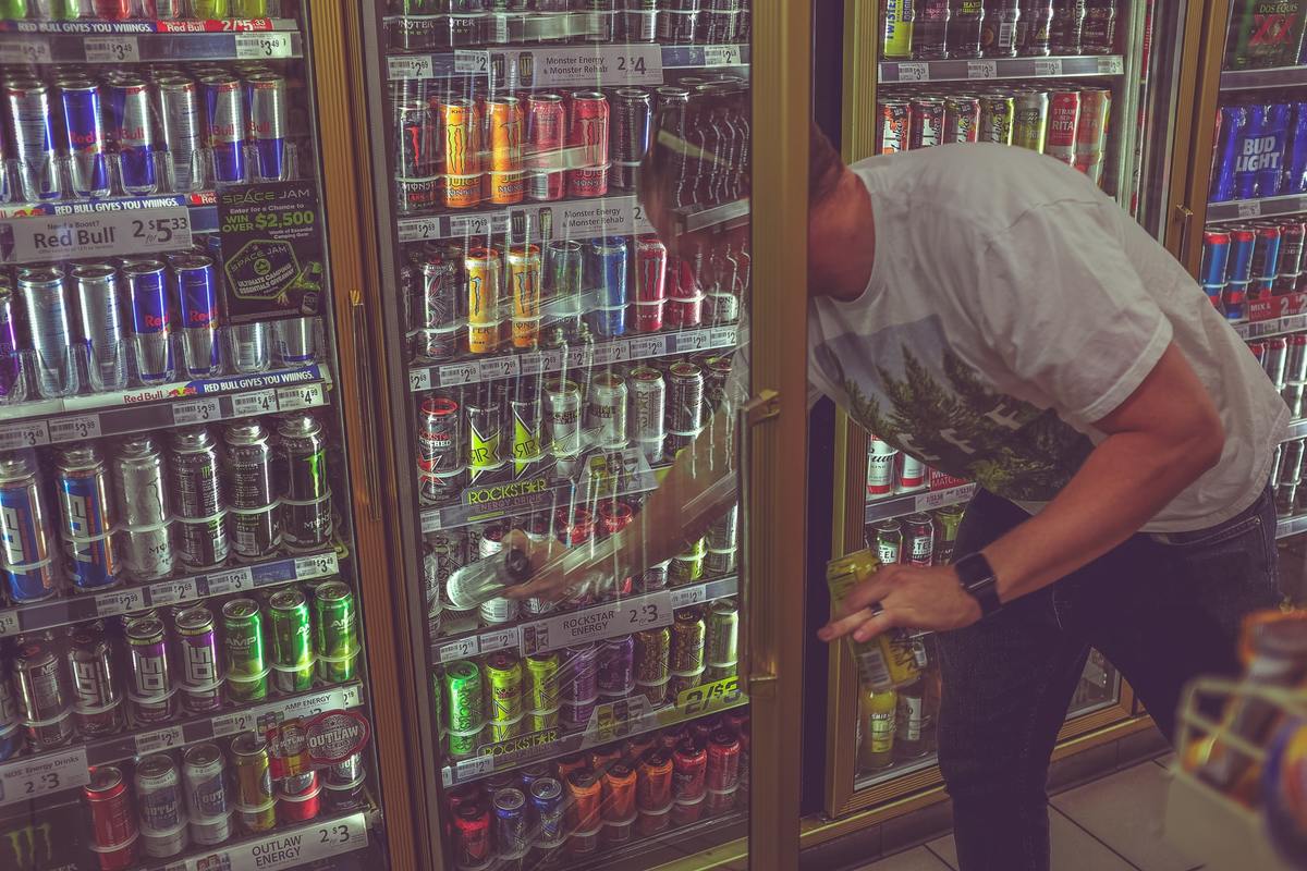 getting energy drink Man reaches into a gas station fridge to get an energy drink.