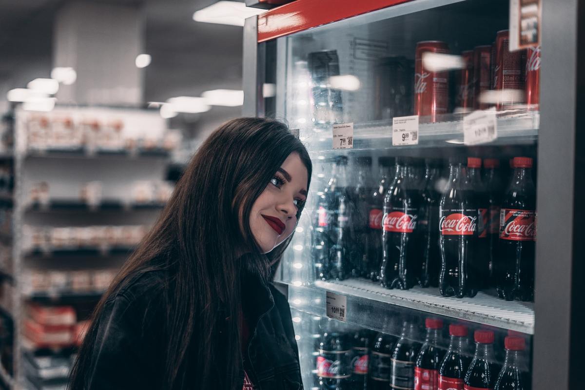 getting soda Woman looks at a fridge full of soda.