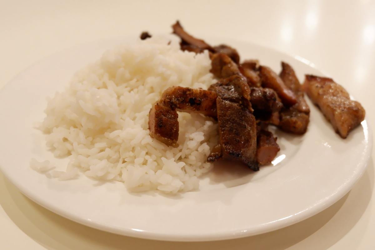 pork and rice A plate holds white rice and pork.