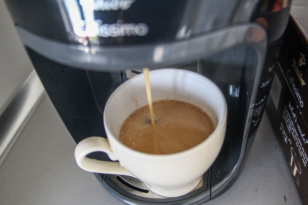 coffee 1161469812 a cup of coffee getting filled by a coffee maker