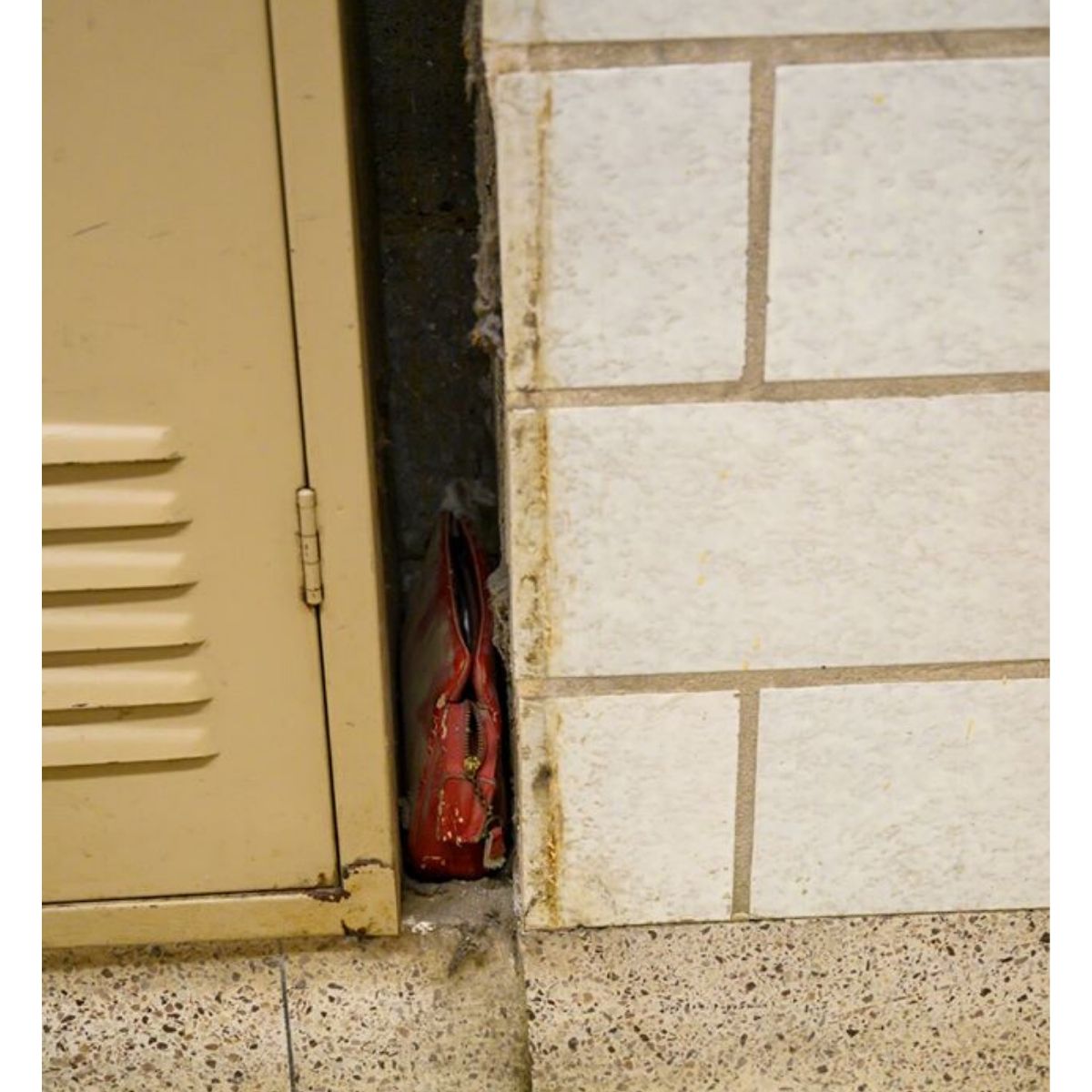 red purse tucked next to lockers