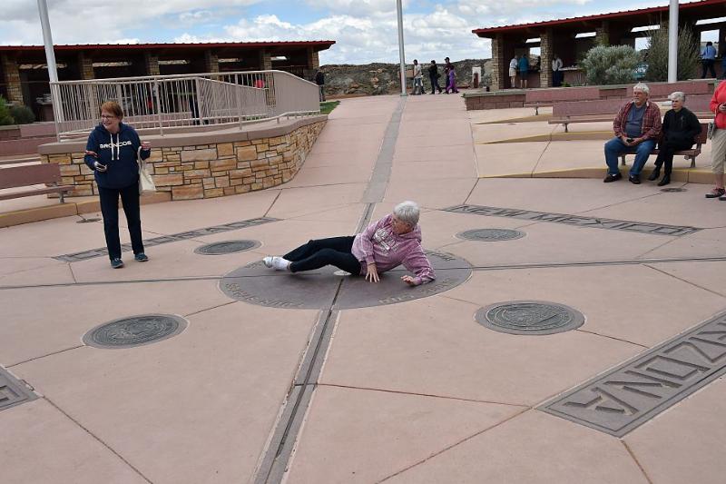 four corners 474685702 an old lady laying down on the ground of the four corners monument