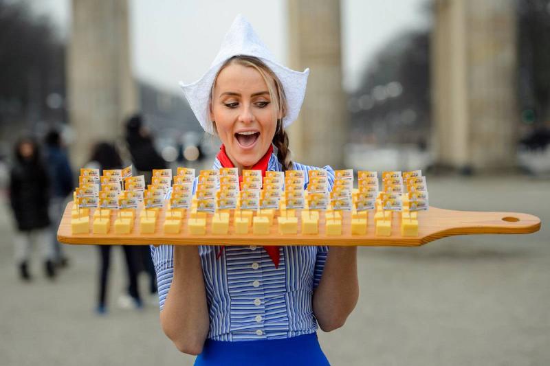 cheese platter - 1039764768 A woman holds an enormous Dutch cheese platter.