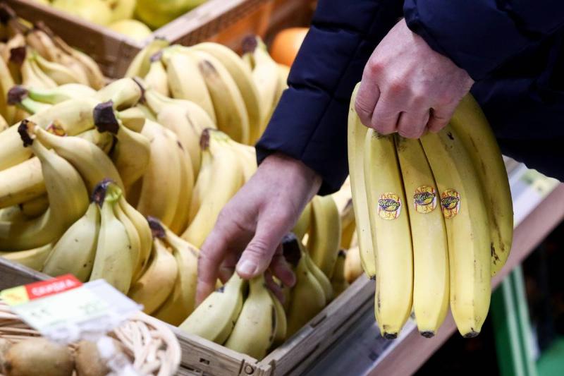 shopping for bananas - 1198749981 A man shops for bundles of bananas at a supermarket.