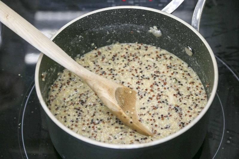 cooking quinoa - 658423454 A person stirs quinoa in a pot.