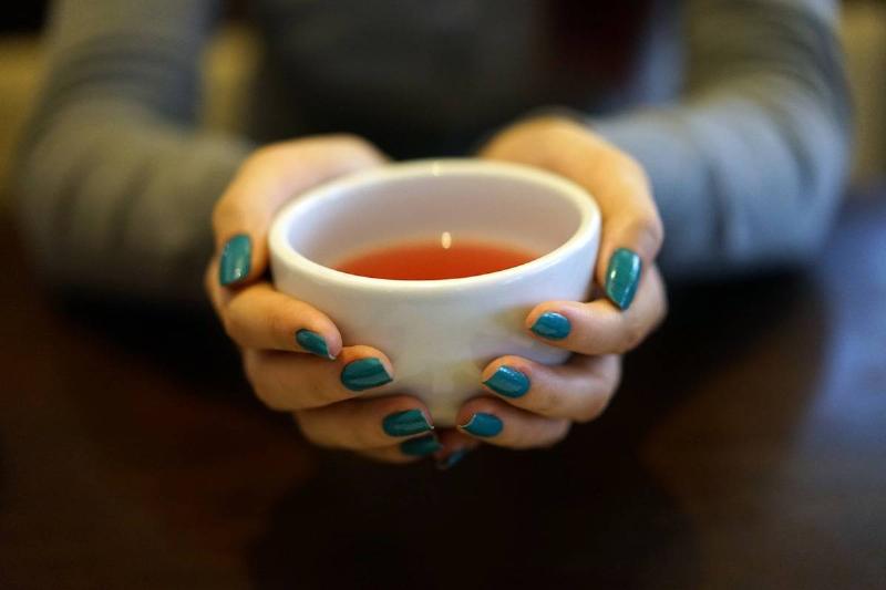 tea A woman holds a cup of tea.