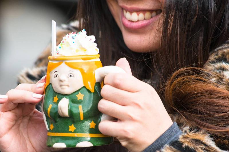 ceramic mug-1164950544 A woman enjoys hot chocolate in a Christmas ceramic mug.