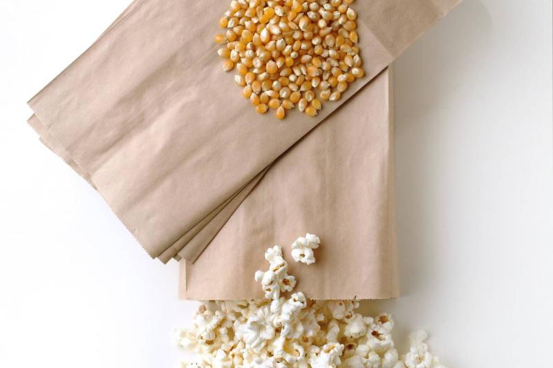 paper bag-96769966 Popcorn pours out of a brown paper bag.