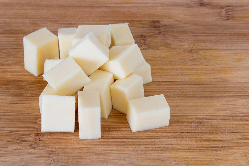 cheese 504725282 white cheese cubes on a wood table