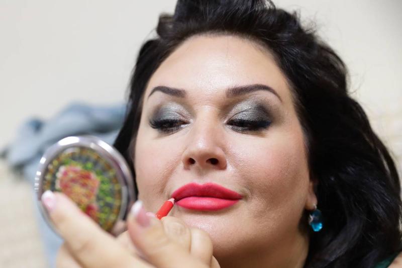 applying lipstick - 1155174625 A beauty pageant model applies lipstick.