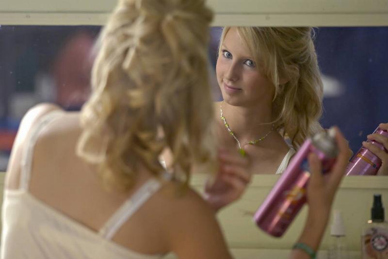 hair spray-1155640122 A woman sprays her hair with product.