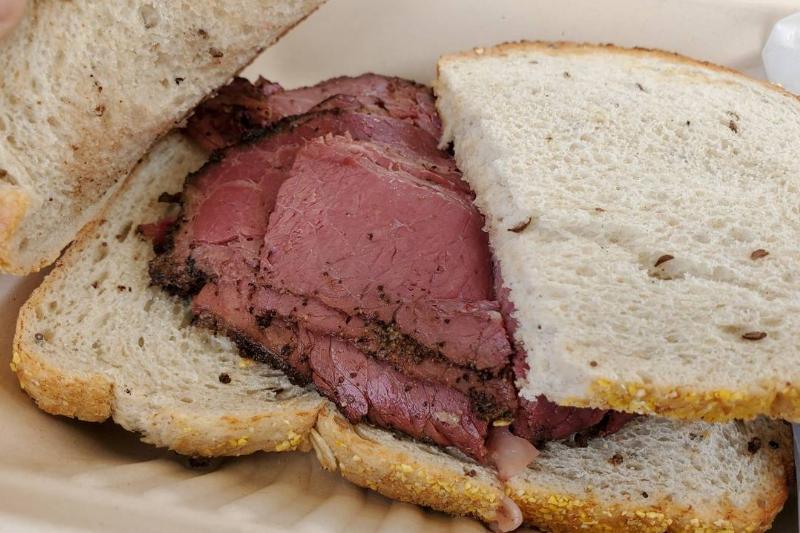 pastrami - 1197314217 Pastrami sits on slices of white bread.