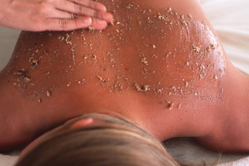 body scrub - 461725624 A woman receives a massage with an exfoliating body scrub.