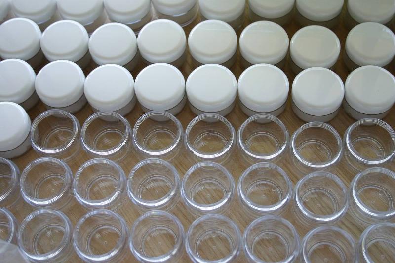 cosmetic jars Rows of cosmetic jars are seen with or without lids.