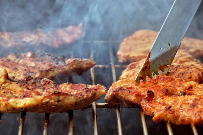 grill Steaks lie on a charcoal grill in a garden