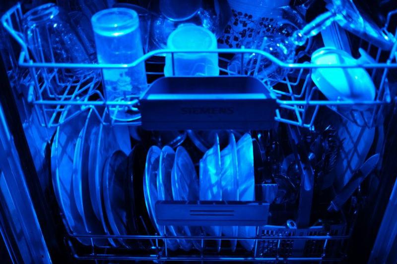dishwasher 13 April 2020, North Rhine-Westphalia, Cologne: Washed dishes are in an open dishwasher with blue lighting. Photo: Oliver Berg/dpa