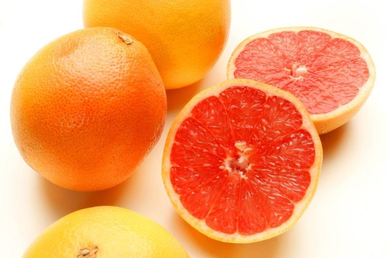 grapefruit-957778476 Grapefruits and grapefruit slices lay against a white background.