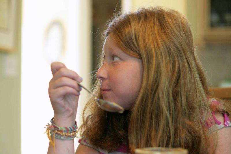 peanut allergy-151238164 A girl eats from a jar of peanut butter.