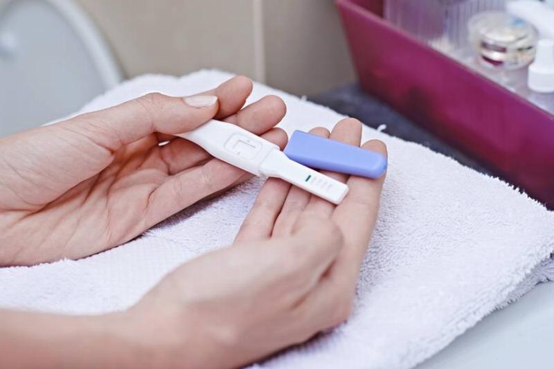 pregnancy test-629430129 A woman holds a pregnancy test.